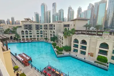 a large swimming pool in front of a city at Gorgeous 1BDR with Burj Khalifa & Fountain Views in Dubai
