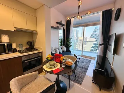 a kitchen and living room with a table in a room at Brand new 1BDR in Vera- Business Bay in Dubai