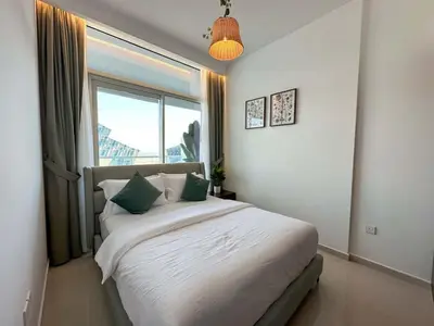 a bedroom with a large white bed with a window at Brand new 1BDR in Vera- Business Bay in Dubai