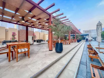 an outdoor patio with wooden tables and benches at Luxurious Studio Flat with Burj Khalifa Views in Dubai