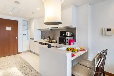 a kitchen with white cabinets and a counter top at Luxurious Studio Flat with Burj Khalifa Views in Dubai