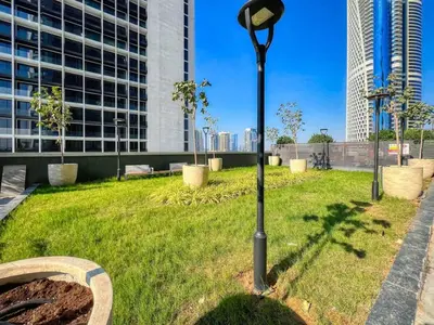 a street light in a park with a building at Luxury 2BDR Apartment with Private Balcony in Dubai