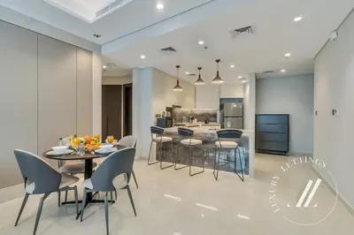 a dining room and kitchen with a table and chairs at Luxury 2BDR Apartment with Private Balcony in Dubai