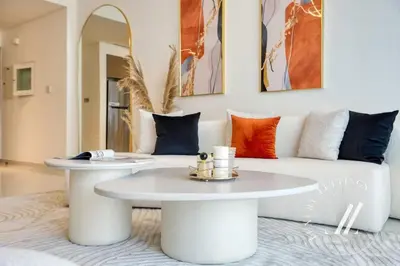 a living room with two tables and a couch at Grand Bleu Tower 2 - 1 BDR with Beachfront Views in Dubai