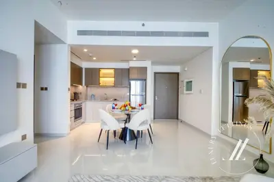 a kitchen and dining room with a table and chairs at Grand Bleu Tower 2 - 1 BDR with Beachfront Views in Dubai