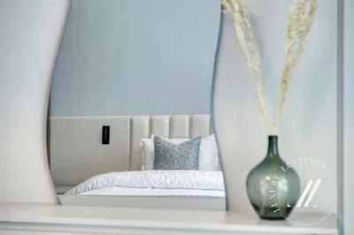 a bedroom with a bed and a vase in a mirror at Grand Bleu Tower 2 - 1 BDR with Beachfront Views in Dubai