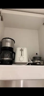 a kitchen shelf with a toaster and a slow cooker at Studio Apartment Near downtown Dubai in Dubai