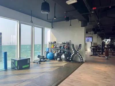 a gym with a bunch of equipment in a room with windows at Luxury 2 BR Spectacular Downtown and Sea View next to metro in Dubai