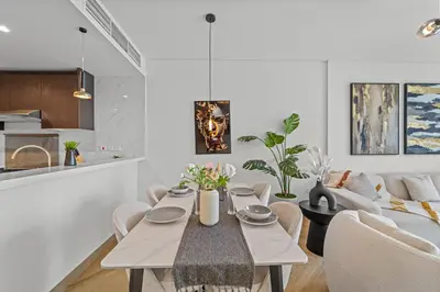 a dining room and living room with a table and chairs at Luxury 2 BR Spectacular Downtown and Sea View next to metro in Dubai