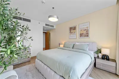a bedroom with a large bed and potted plants at Luxury 2 BR Spectacular Downtown and Sea View next to metro in Dubai