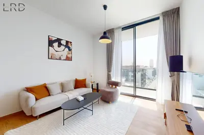 a living room with a couch and a table at Brand New and Modern 1BR in Dubai