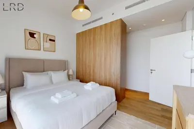 a bedroom with a large bed with two towels on it at Brand New and Modern 1BR in Dubai