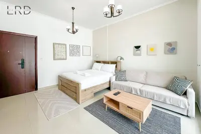 a living room with a bed and a couch at Cozy Studio in Dubai Marina in Dubai