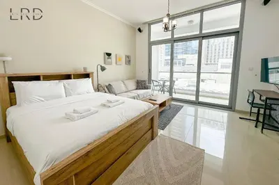 a bedroom with a large bed and a couch at Cozy Studio in Dubai Marina in Dubai