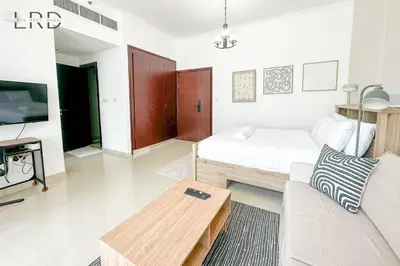 a living room with a bed and a couch at Cozy Studio in Dubai Marina in Dubai