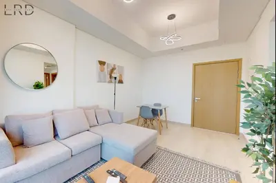 a living room with a blue couch and a mirror at Modern 1BR with Canal View in Dubai