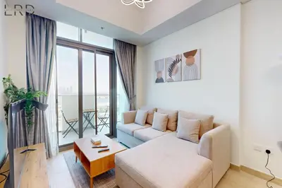 a living room with a couch and a large window at Cozy 1BR with Canal View in Dubai