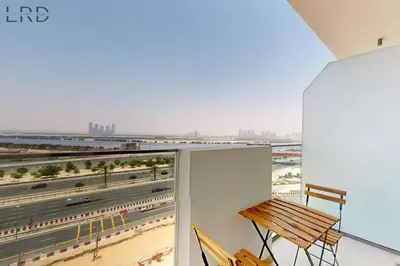 a balcony with a bench and a view of a highway at Cozy 1BR with Canal View in Dubai