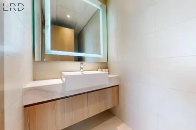 a bathroom with a white sink and a mirror at Cozy 1BR with Canal View in Dubai