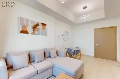 a living room with a couch and a table at Cozy 1BR with Canal View in Dubai