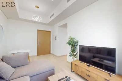 a living room with a couch and a flat screen tv at Charming 1BR with Canal View in Dubai