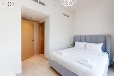 a bedroom with a large bed with a blue headboard at Charming 1BR with Canal View in Dubai