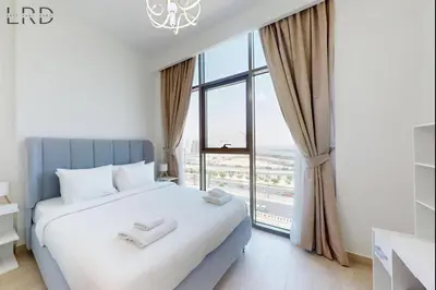 a bedroom with a bed and a large window at Charming 1BR with Canal View in Dubai