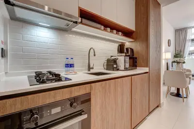 a kitchen with a sink and a stove top oven at PVH - Contemporary Studio - Prime Residency 3 in Dubai