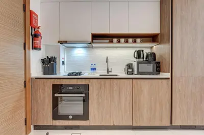 a kitchen with a sink and a stove top oven at PVH - Contemporary Studio - Prime Residency 3 in Dubai