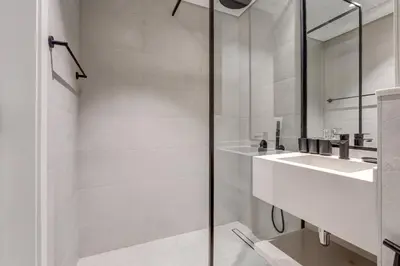 a white bathroom with a sink and a shower at PVH - Contemporary Studio - Prime Residency 3 in Dubai