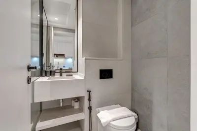 a bathroom with a toilet and a sink and a mirror at PVH - Contemporary Studio - Prime Residency 3 in Dubai