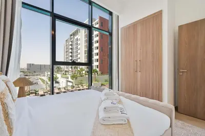 a bedroom with a white bed with a large window at PVH - Chic 1BR in Azizi Riviera 37 in Dubai