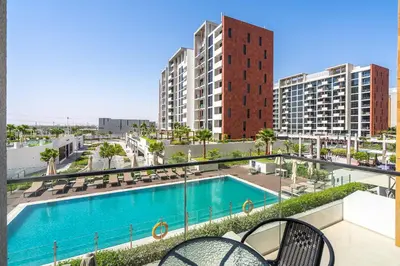 an apartment with a swimming pool and some buildings at PVH - Chic 1BR in Azizi Riviera 37 in Dubai