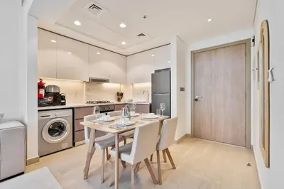 a kitchen and dining room with a table and chairs at PVH - Chic 1BR in Azizi Riviera 37 in Dubai