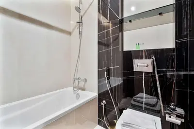 a bathroom with a toilet and a bath tub at PVH - Chic Furnished Studio in JLT - Me Do Re in Dubai