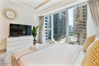 a bedroom with a large white bed and a large window at PVH - Chic Furnished Studio in JLT - Me Do Re in Dubai