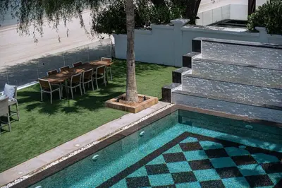 a pool in a yard with a table and a tree at Luxury Palm Villa with direct private beach access in Dubai