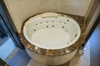 a bath tub in a bathroom with a granite counter top at Luxury Palm Villa with direct private beach access in Dubai