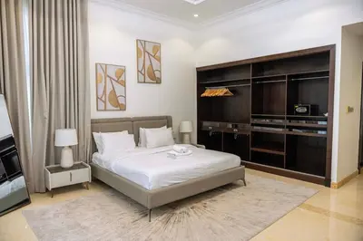 a bedroom with a large bed and a television at Luxury Palm Villa with direct private beach access in Dubai