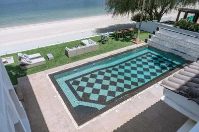 a swimming pool with a checkerboardkered sidx sidx sidx sidx at Luxury Palm Villa with direct private beach access in Dubai
