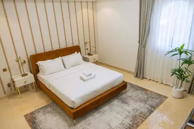 a bedroom with a bed with white sheets and white pillows at Luxury Palm Villa with direct private beach access in Dubai