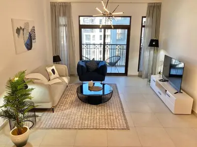 a living room with a couch and a tv at Rahaal 1 BDR, Madinat Jumeirah in Dubai
