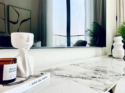 a table with a white vase and a candle on it at Aesthetic 1br In Binghatti House Free Pool Gym in Dubai