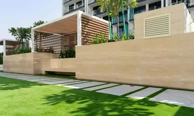 a fence in front of a building with green grass at Aesthetic 1br In Binghatti House Free Pool Gym in Dubai