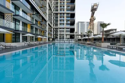 a large swimming pool with blue water in a building at Velvet 1br Serenity Pool View & Free Amenities! in Dubai