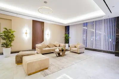 a living room with a couch and chairs and a table at Luxury Studio Pool & Gym Access in Dubai Sports City in Dubai