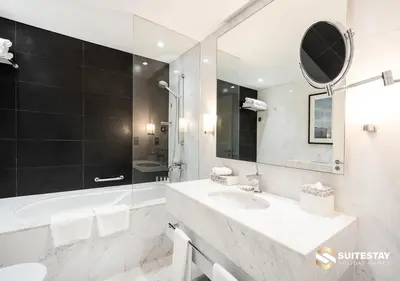 a white bathroom with a sink and a mirror at Fashion Avenue Dubai Mall in Dubai