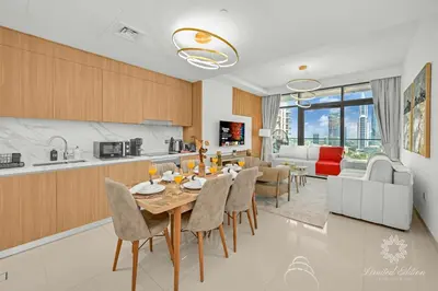 a kitchen and living room with a table and chairs at Luxury 2 Bedroom Apartment - Private Beach - Emaar Beach Vista in Dubai