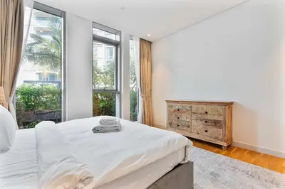 a bedroom with a bed and a large window at PVH - Tranquil 2BR - Bluewaters Residences 5 in Dubai