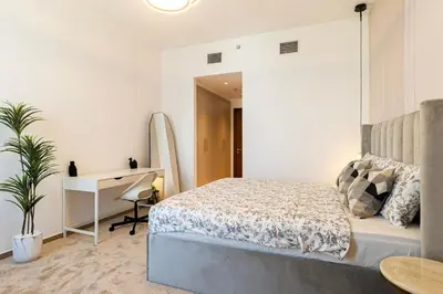 a bedroom with a bed and a desk and a table at Luxury 4BHK in Business Bay w Burj Khalifa View Noora 4203 in Dubai